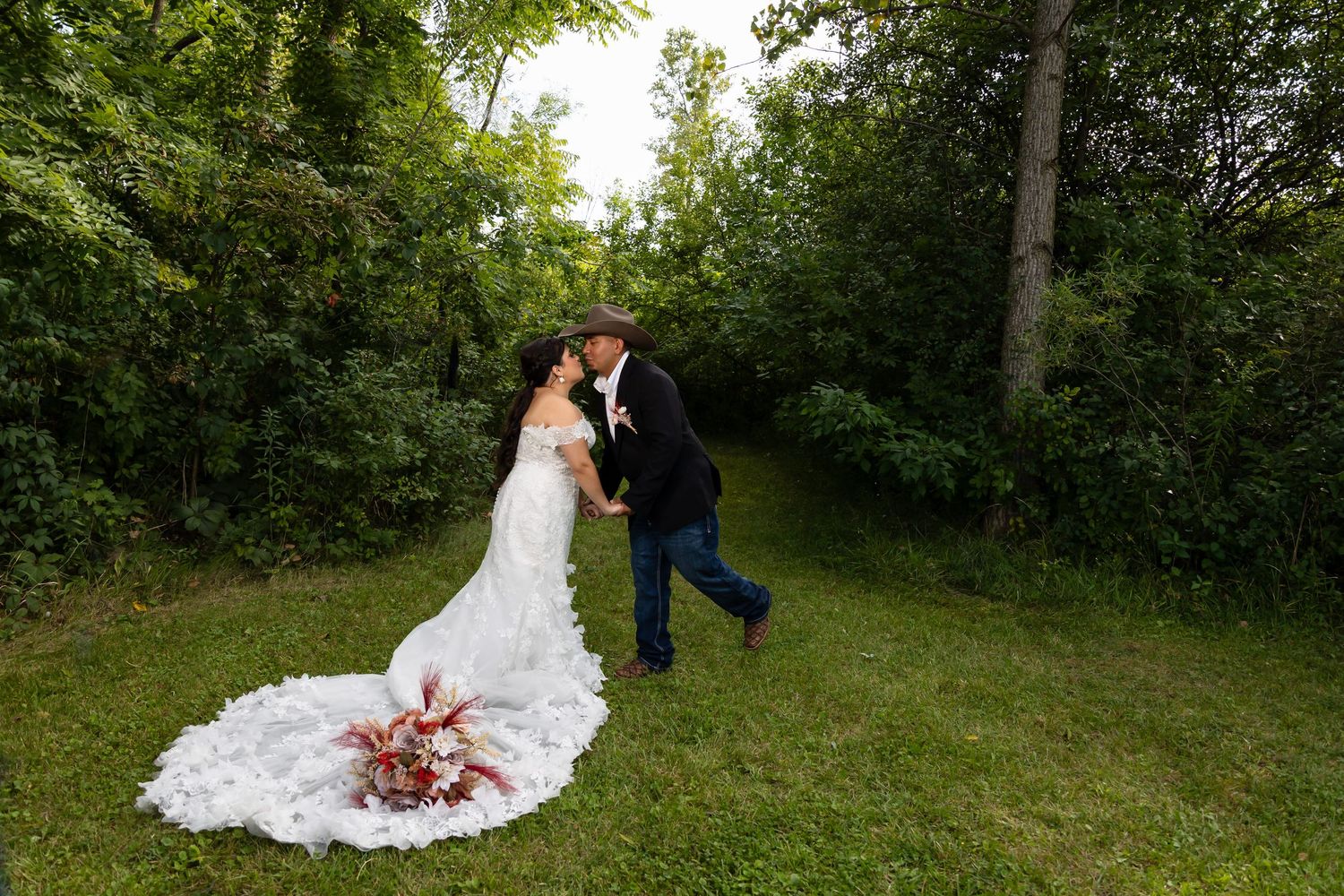 Bride and groom sharing a kiss under a floral archway. Beautiful outdoor wedding ceremony photography in Lake County by Alex T.