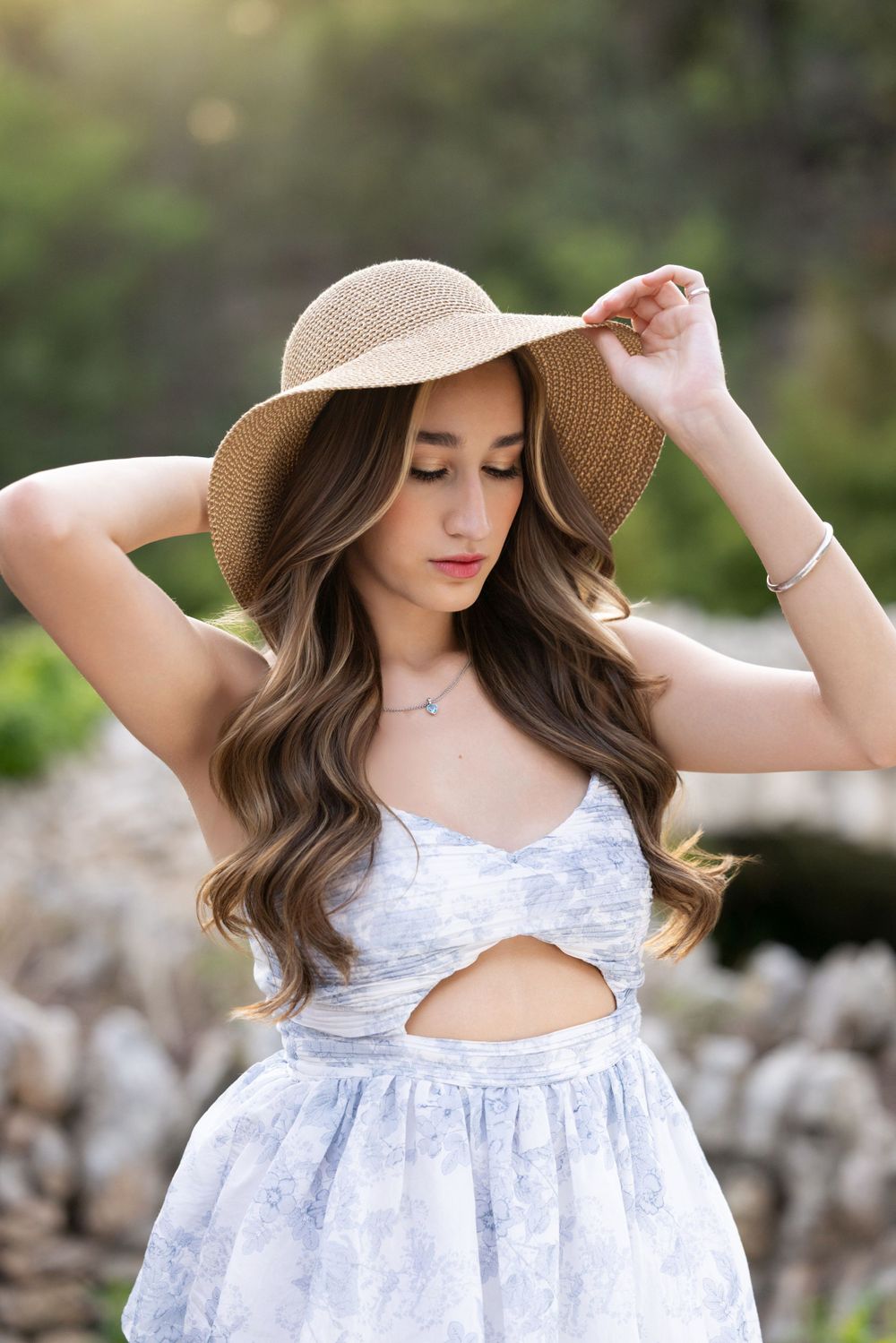 Elegant summer outfit featuring a white floral dress with cutout detail and a beige wide-brimmed straw sun hat.