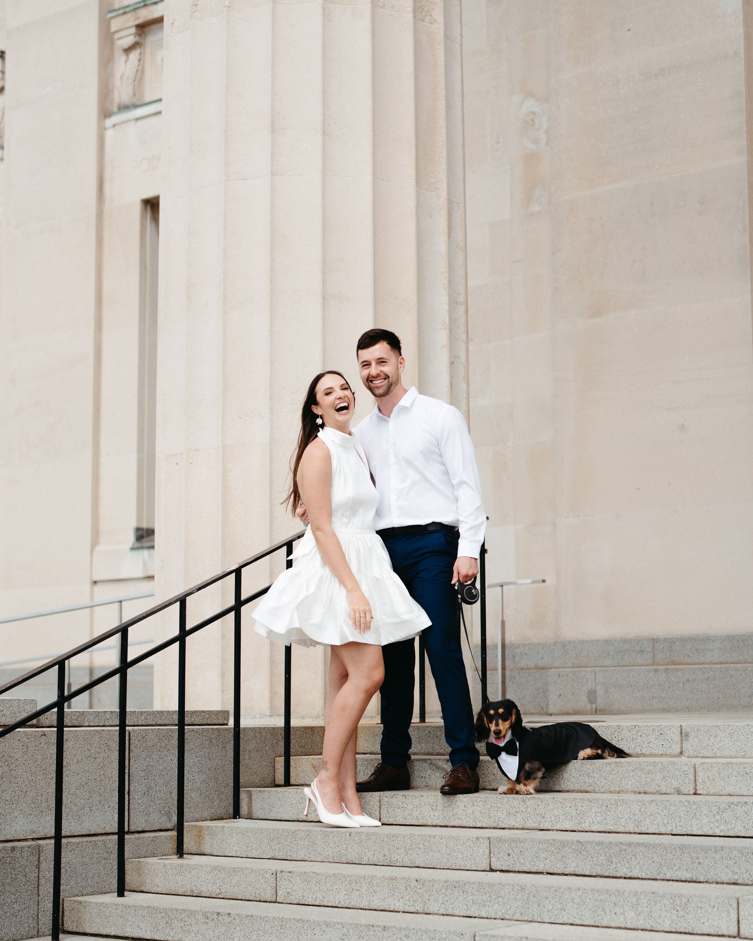 A couple sits on stone steps with their dog, captured in a series of casual romantic poses against a light building facade.