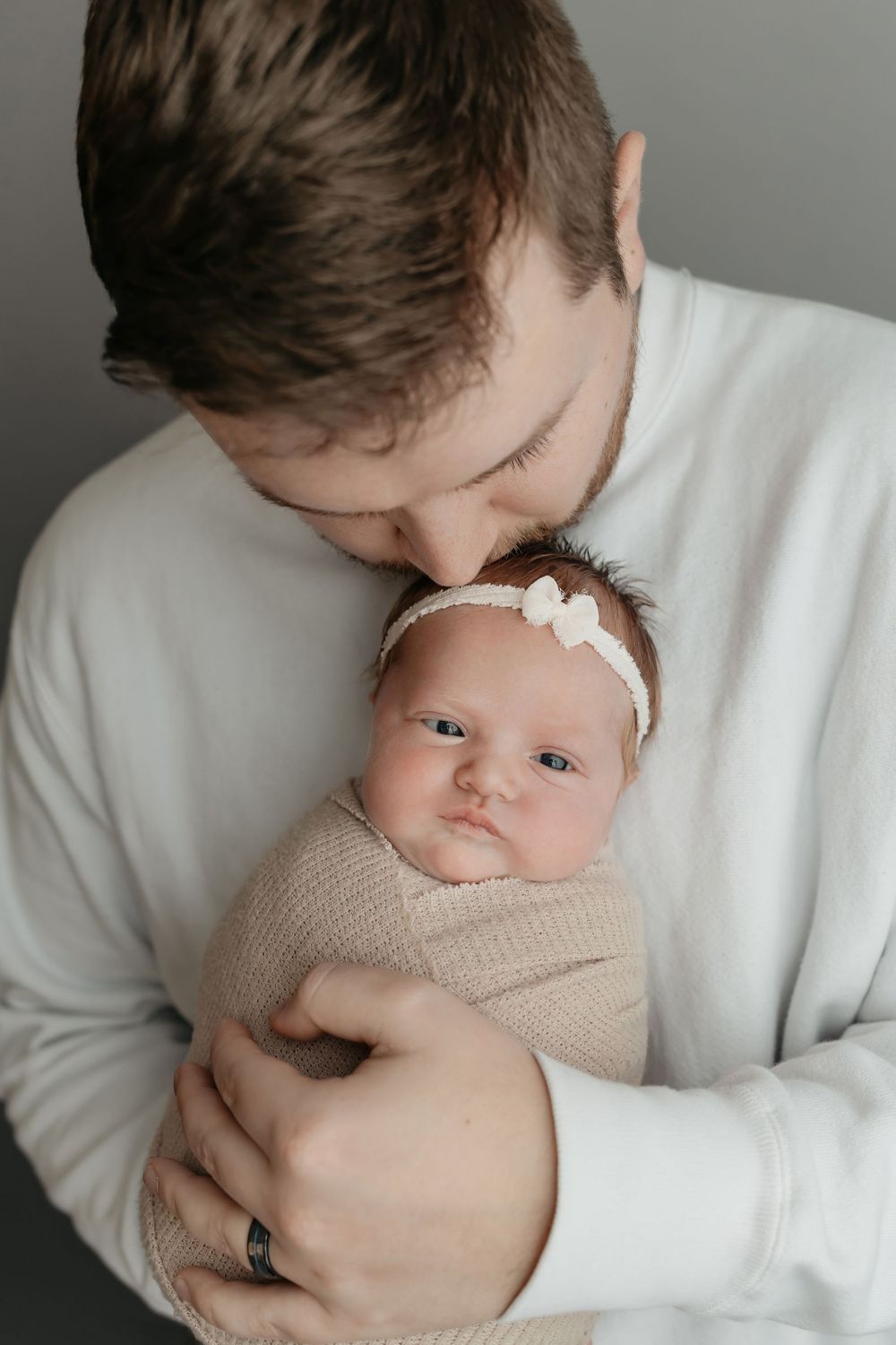 Newborn girl in dad's arms in cream wrap, taken by Jen Knightstep, Photographer