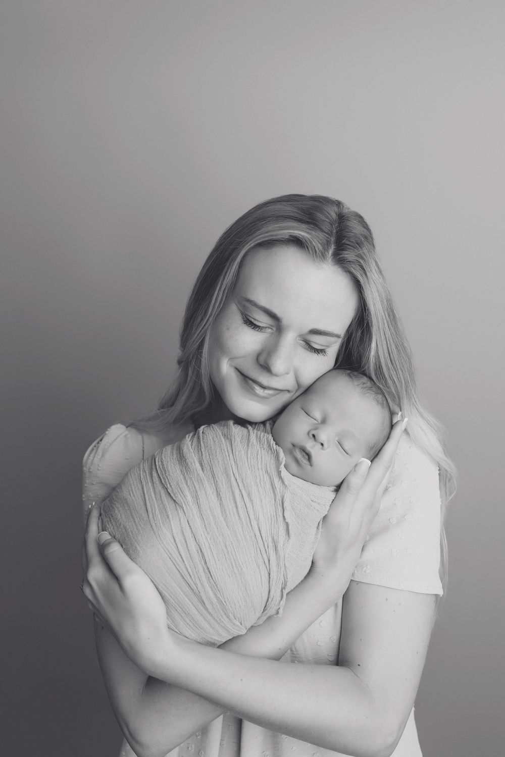 Mother cuddling newborn baby, in black and white, taken by Jen Knightstep, Photographer