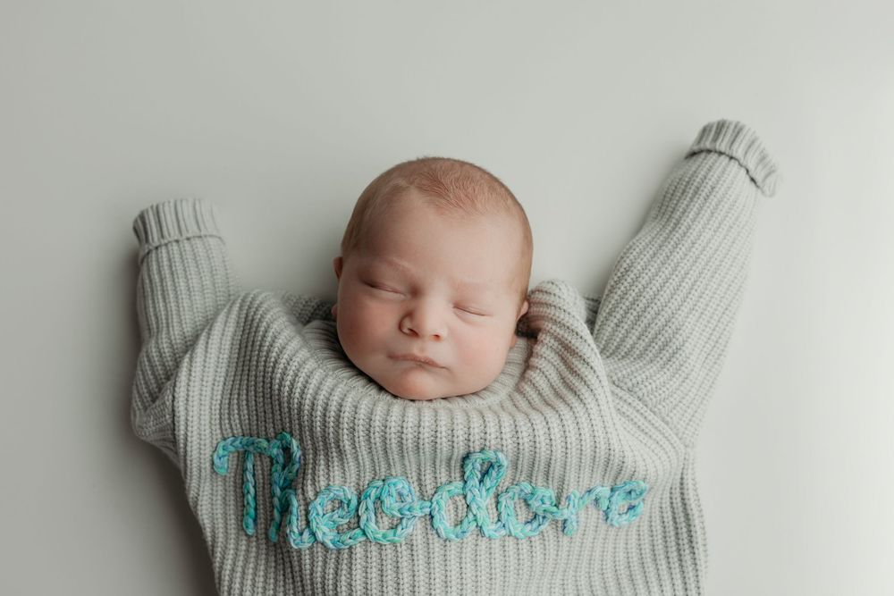 Newborn boy in oversized sweater,  taken by Jen Knightstep, Photographer