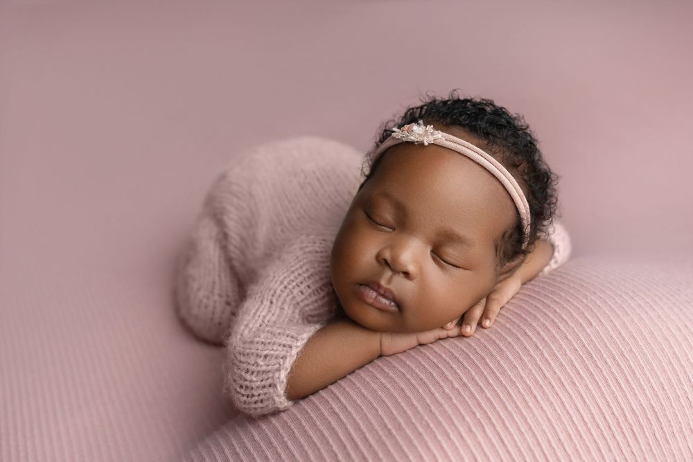 Newborn girl in pink on pink background, taken by Jen Knightstep, Photographer