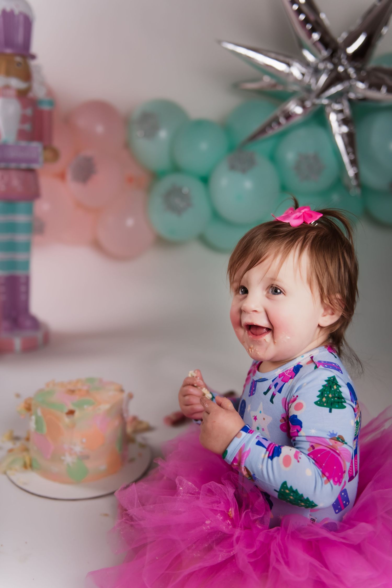 A festive birthday celebration scene with a pink tutu, pastel cake, and teal balloon decorations.