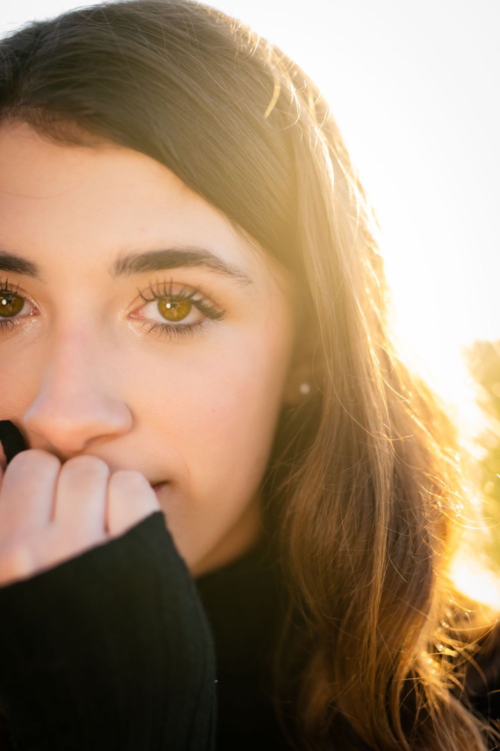 A backlit portrait series shows a person with long hair in warm sunlight against a white background.