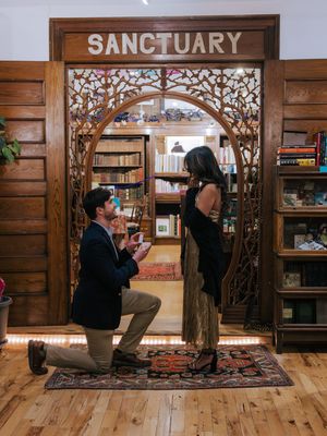 A couple stands in a rustic sanctuary with wooden walls and decorative elements during a wedding ceremony.
