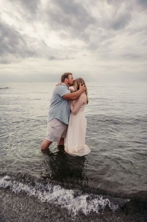 A romantic series of ocean photos with a couple embracing and falling into the surf at sunset.