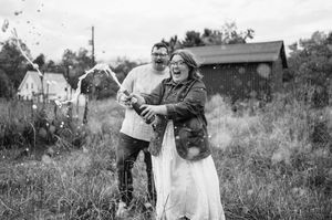 A black and white vintage photograph of people dancing together in a rural outdoor setting.