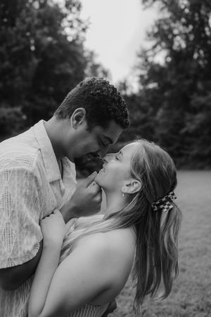 A romantic black and white photo sequence shows a couple sharing tender kisses in a natural outdoor setting.