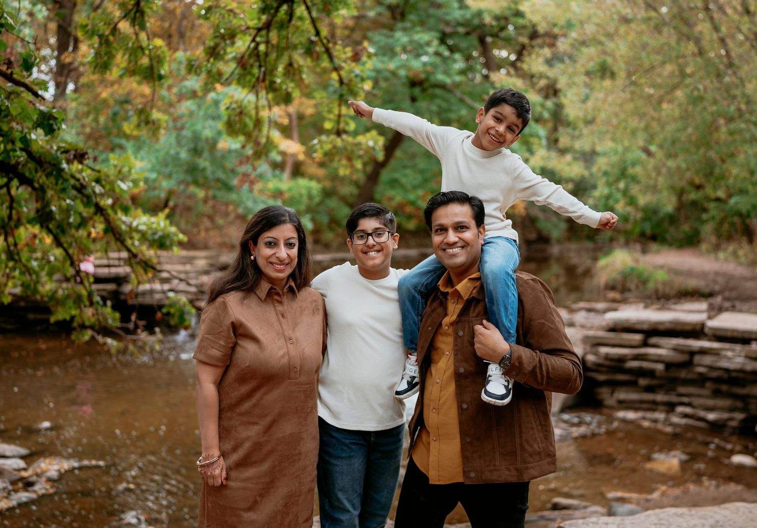 An intimate family portrait captured in a meadow during sunset with warm golden lighting.
