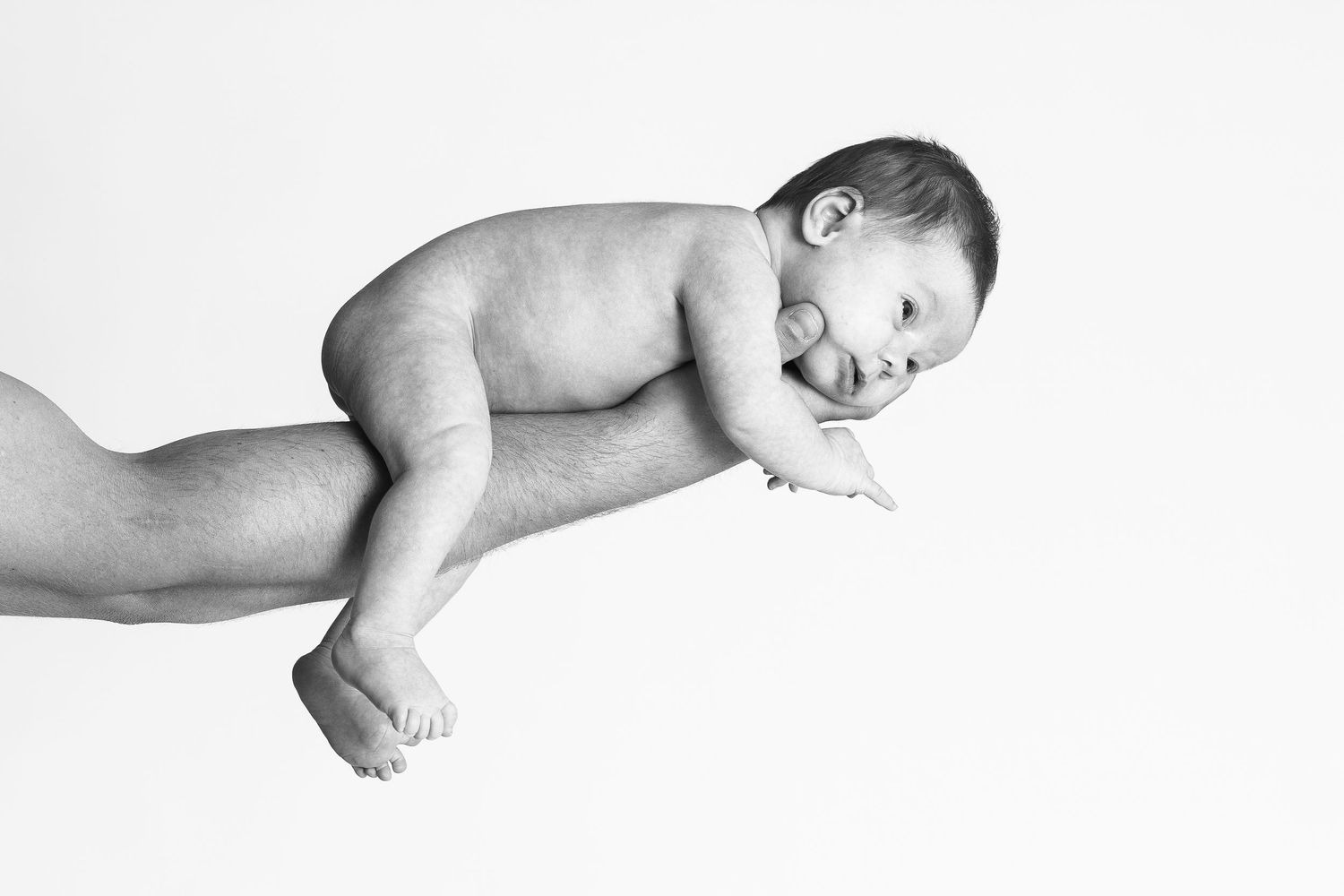 Nyfødt baby hviler trygt på fars arm – newborn fotografering i Jægerspris, Frederikssund og Nordsjælland