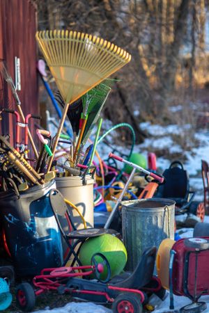 Collection of garden tools and equipment arranged against a rustic background.