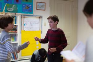 Students engaged in an activity in a classroom with artwork displayed on the walls.