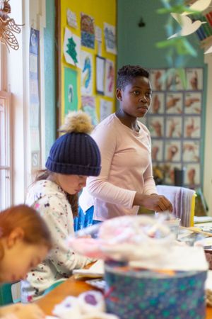 Students working at desks in a colorful classroom with artwork on walls.