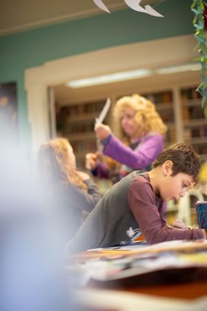 Students focus on their studies in a bright classroom environment.