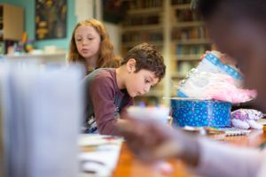 Close-up view of students working at desks in a classroom setting.