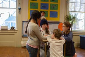 Students participate in an interactive learning activity in a sunlit classroom.
