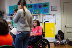 A classroom scene with students and an instructor against a wall decorated with sea-themed artwork.
