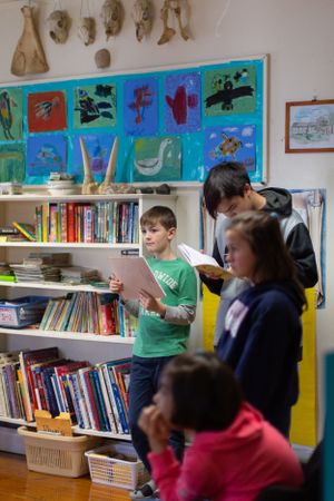 Library setting with colorful artwork displays and bookshelves along the wall.
