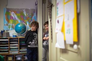 A classroom setting with maps and a globe visible on the walls.