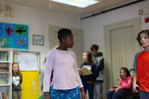 Group of students moving around in an educational space with decorated walls.
