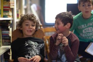 Students seated and engaged in discussion in a classroom setting.