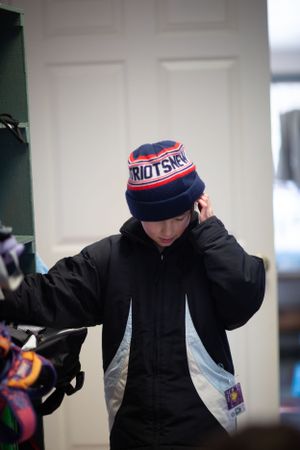 Person in a black hoodie and winter hat performing dynamic movements.
