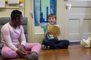 Students sitting on the floor in a classroom during reading time.