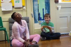 Students engaged in individual reading activities on a classroom floor.