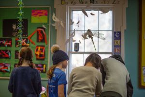 Green classroom walls decorated with artwork and educational materials.