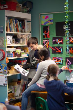 Students focused on work in a classroom decorated with colorful art and educational materials.