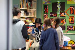 A classroom scene with colorful artwork displayed on green walls.