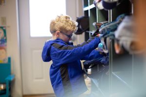 Students engaged in hands-on learning activities at classroom workstations.