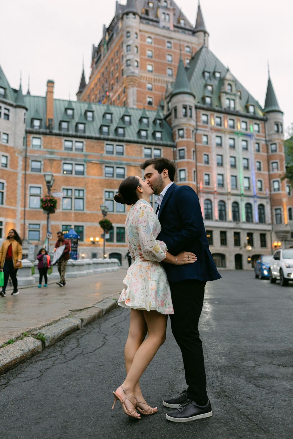 Couple sharing a romantic kiss in front of the iconic Chateau Frontenac in Quebec City, Canada.