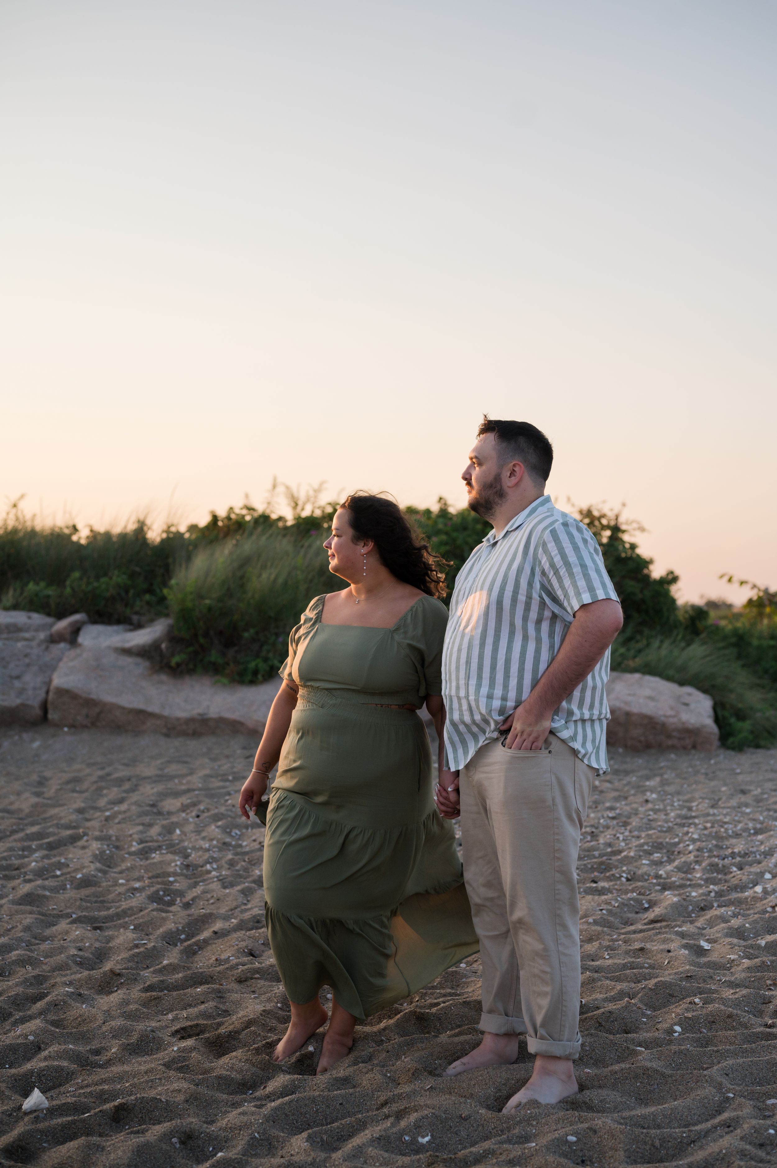 Couple enjoys a romantic sunset moment together on a sandy beach. Hammonasset Beach State Park