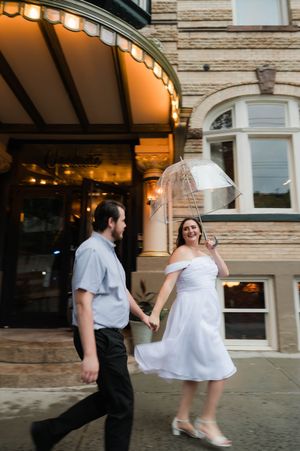 Two people dance and twirl under a stone building's ornate entrance. Graduate Hotel by Hilton New Haven