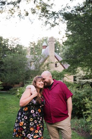 Couple sharing intimate moments in a garden with buildings in background. Edgerton Park Hamden New Haven Connecticut