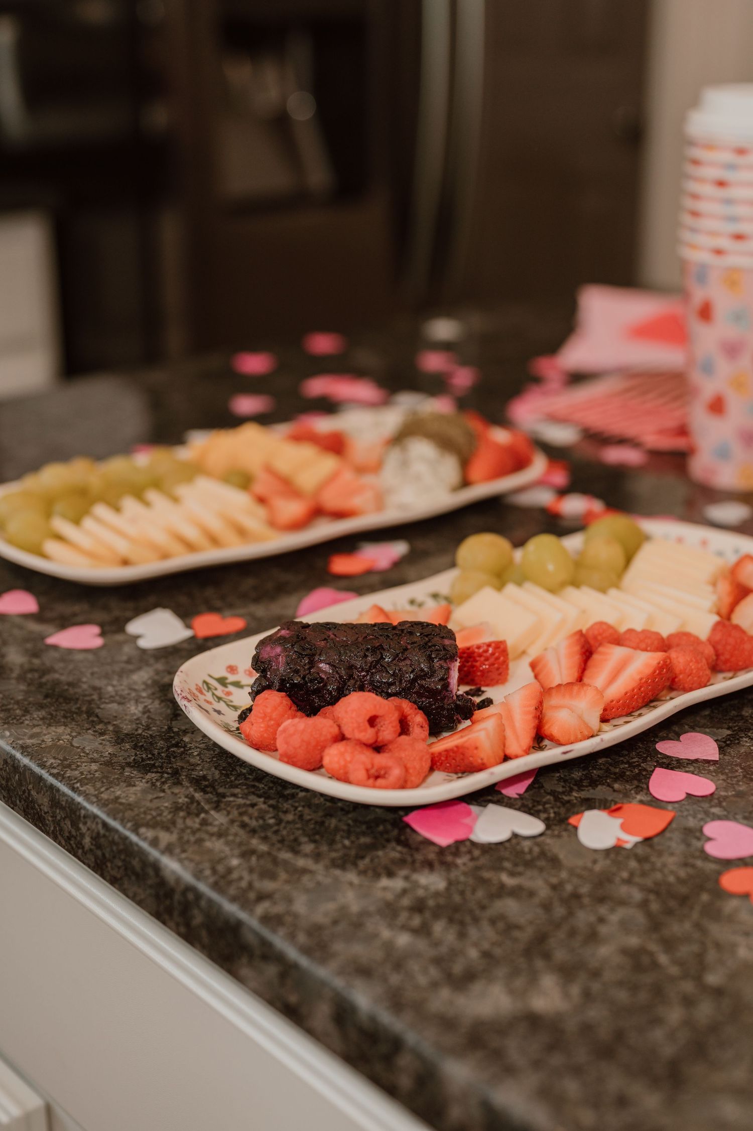Fresh fruit platters and pink heart decorations arranged on granite countertop for Valentine's Day. photo by Samantha Campbell imagery