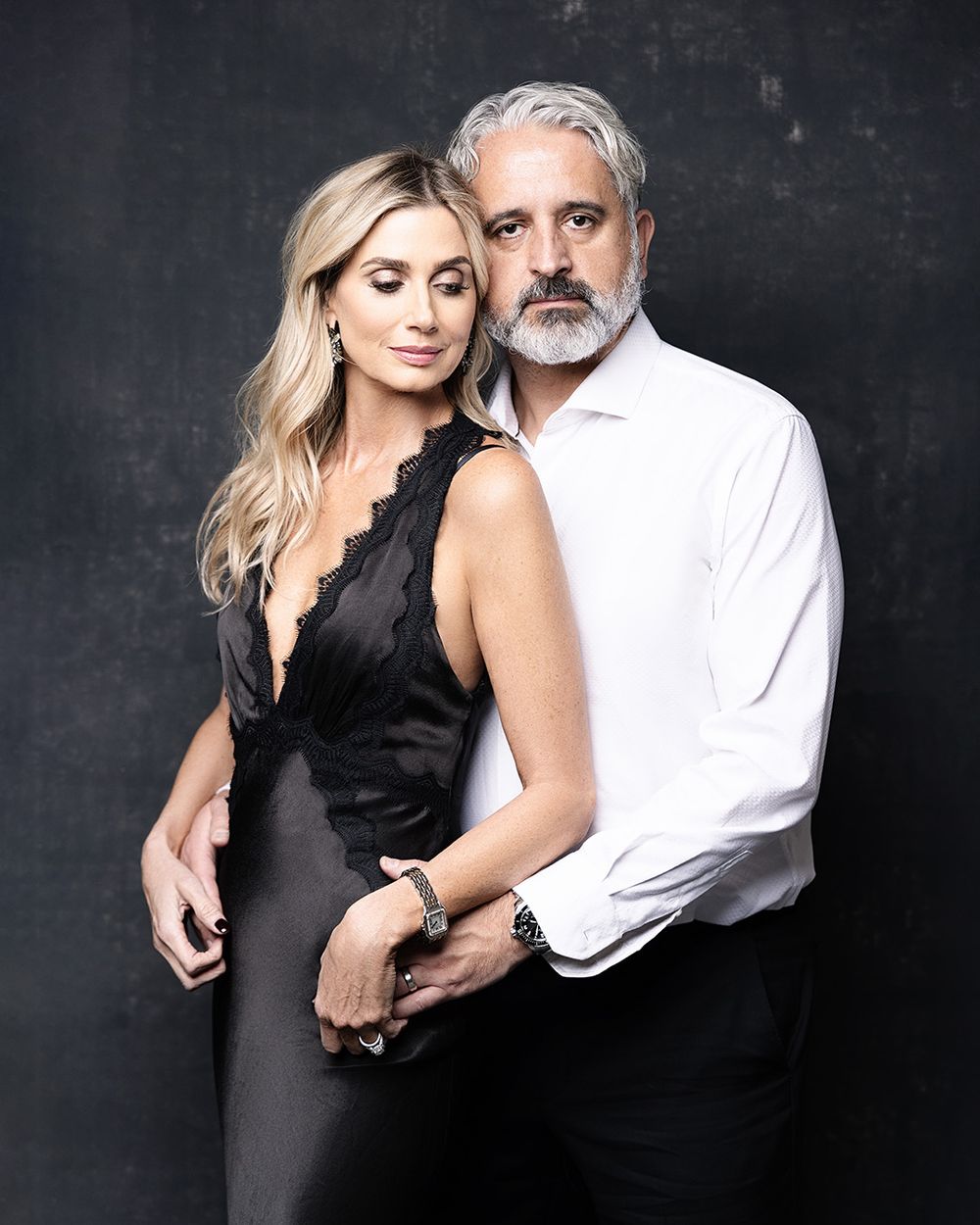 Glamorous studio portrait of a couple in formal black and white attire against dark background. Atlanta family photographer.