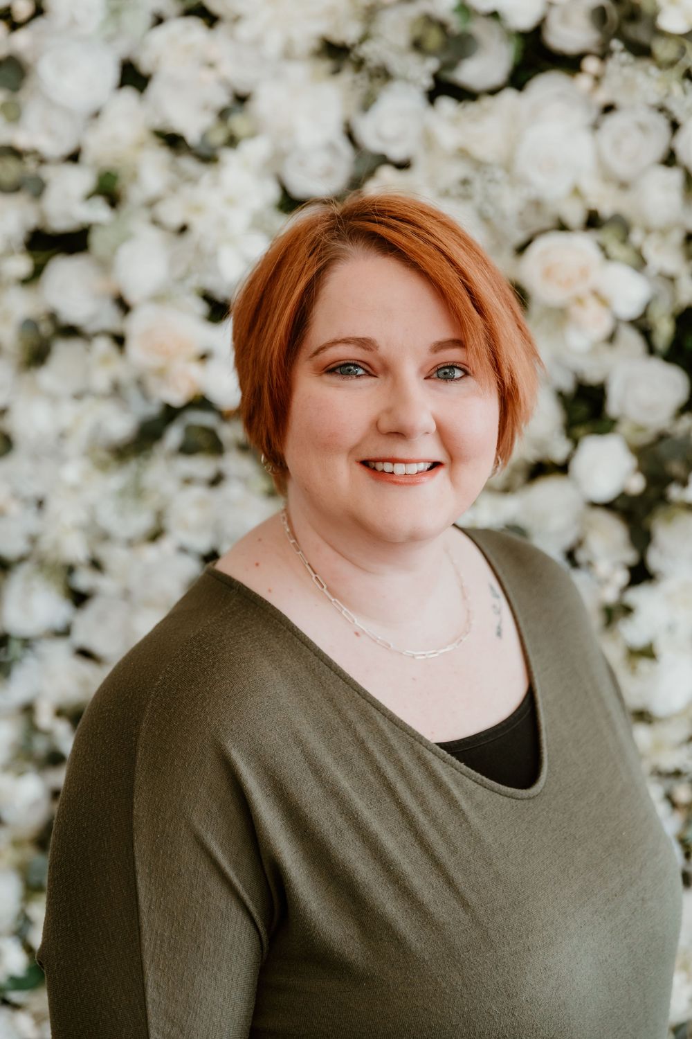 A series of four headshots against a white floral backdrop shows a person in an olive green v-neck top.