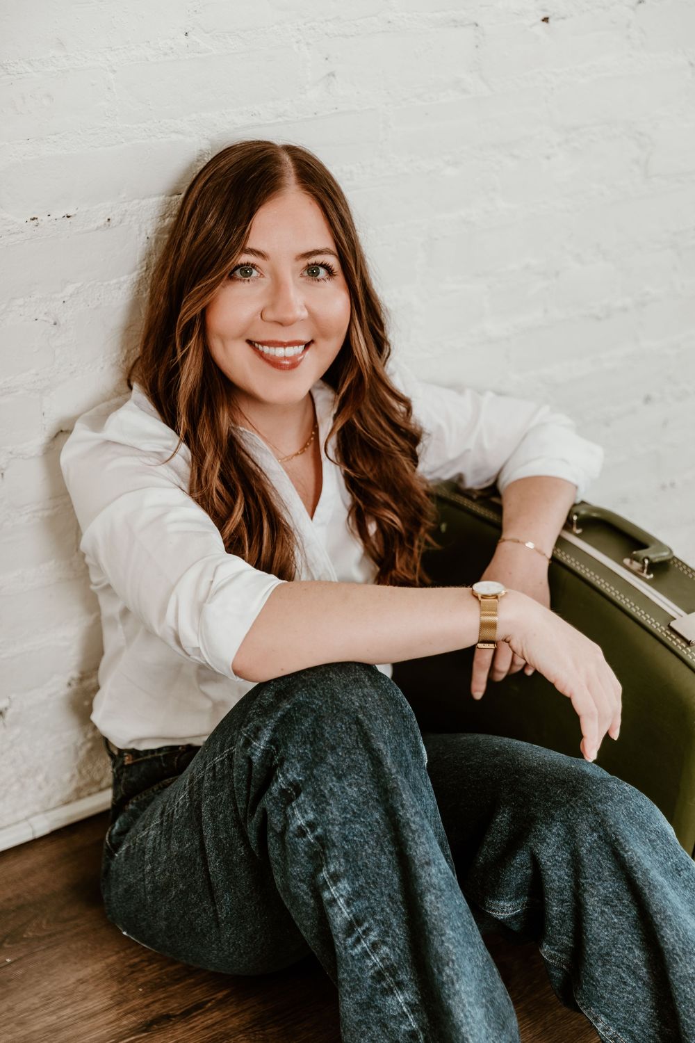 A person in a white button-down shirt and dark pants sits casually against a white wall in a series of lifestyle photos.