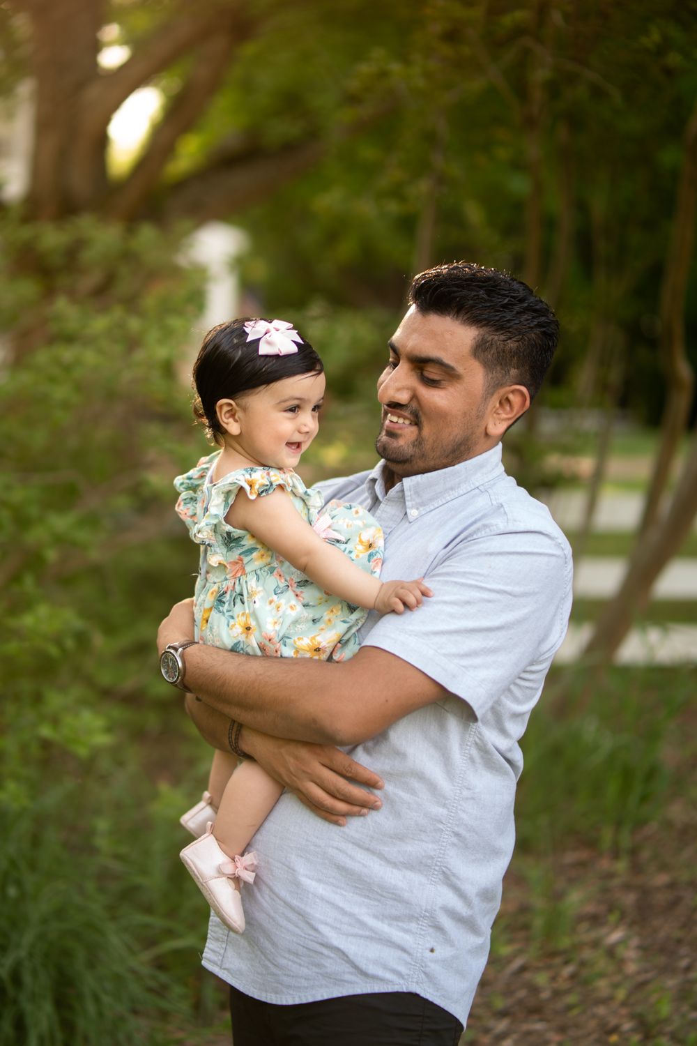 A dad holding his young daughter who is smiling