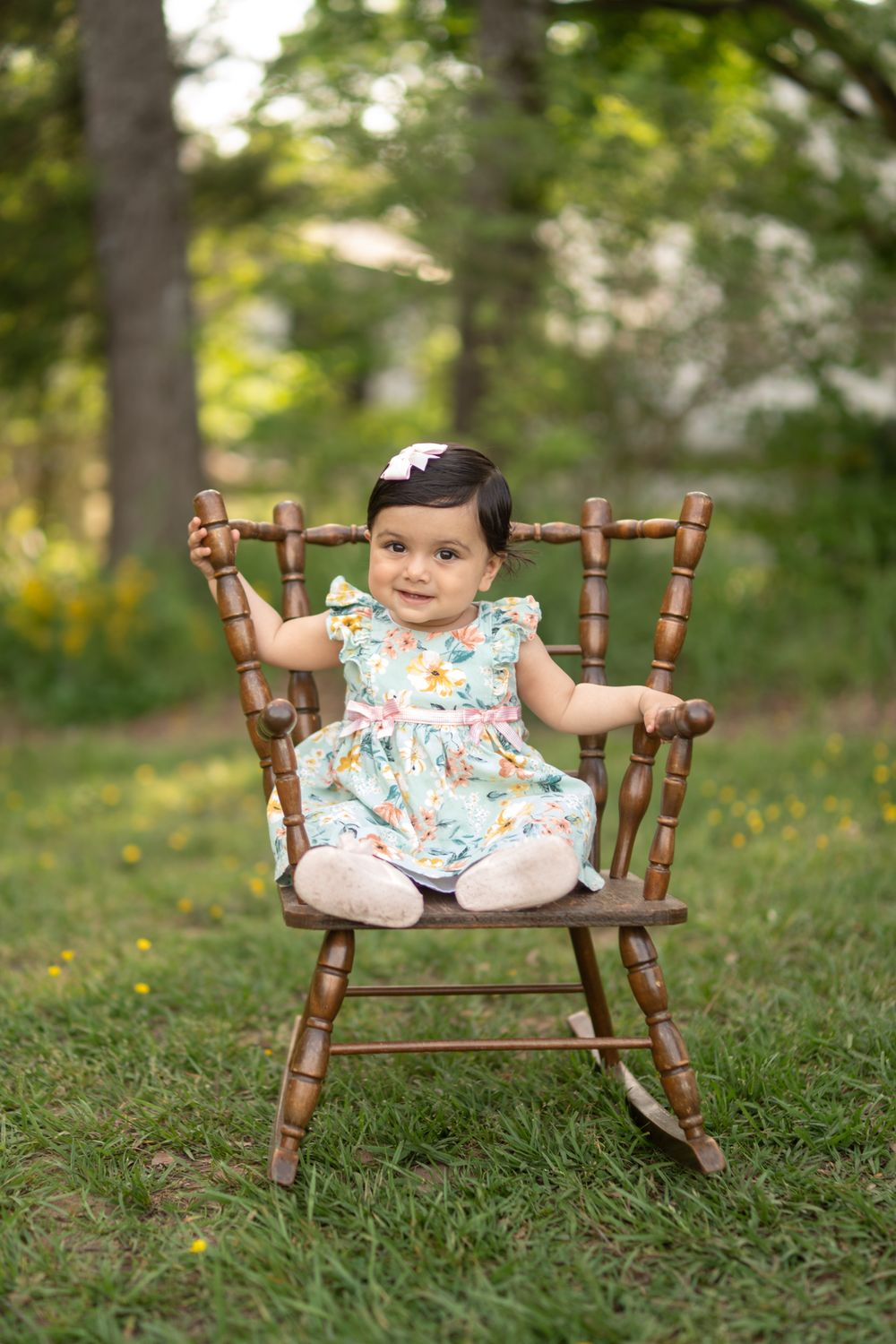 Young child sitting in a rocking chair smiling at the camera
