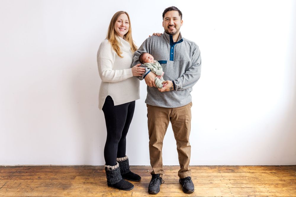 Family lifestyle photography session against white wall showing tender moments.