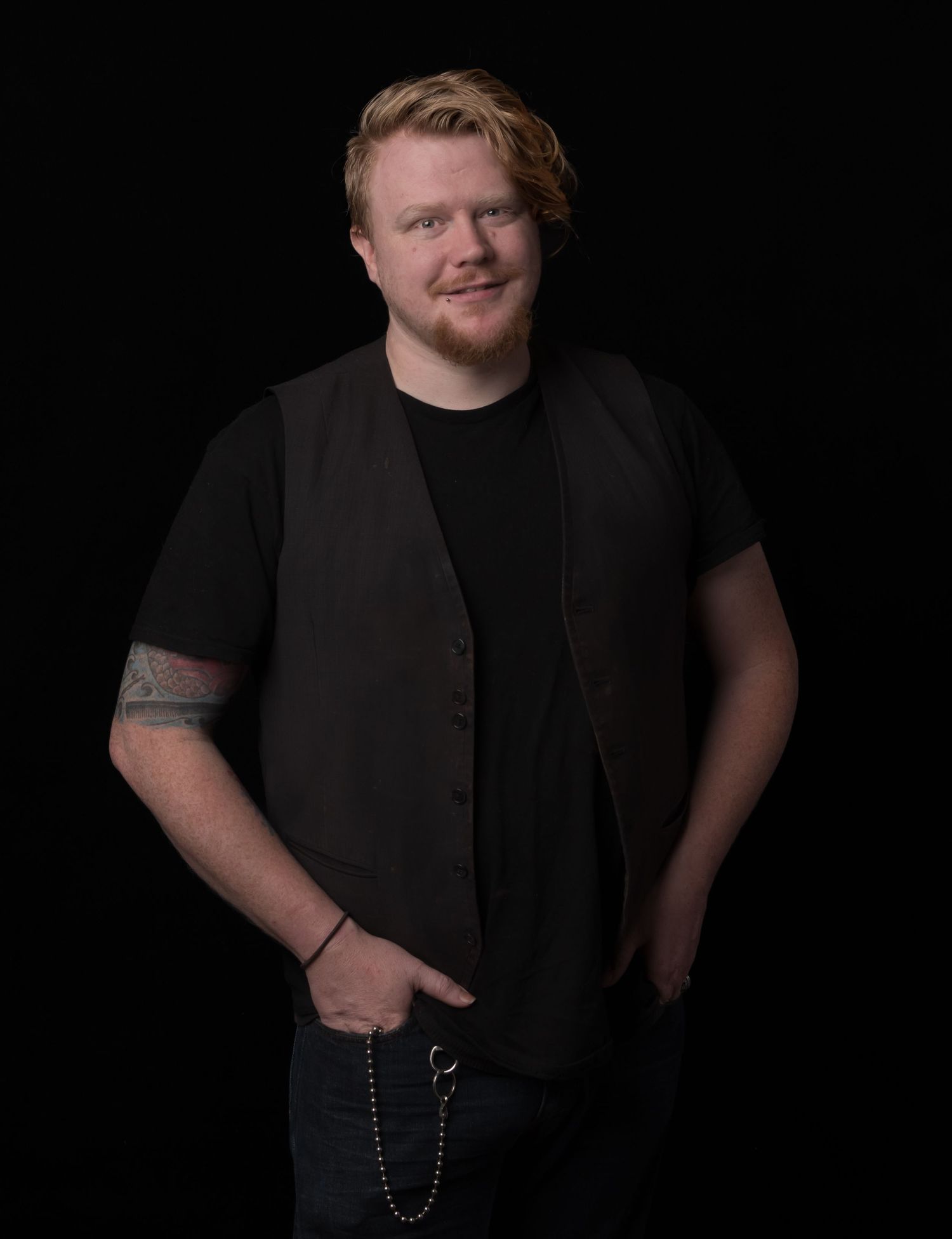 Professional studio portraits against dark background showcasing casual style and black attire.