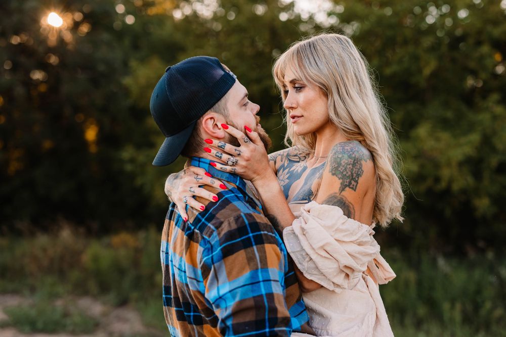 A tender moment between a couple in casual outdoor wear during golden hour.