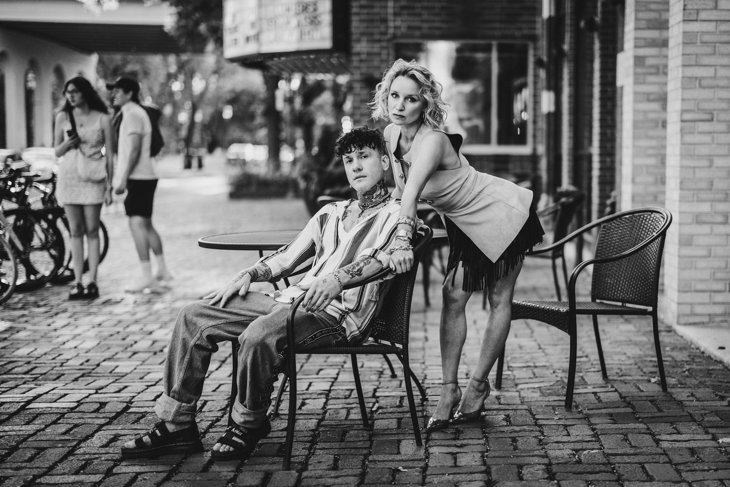 A series of black and white street photography shots showing people sitting at outdoor cafes and walking along cobblestone streets.