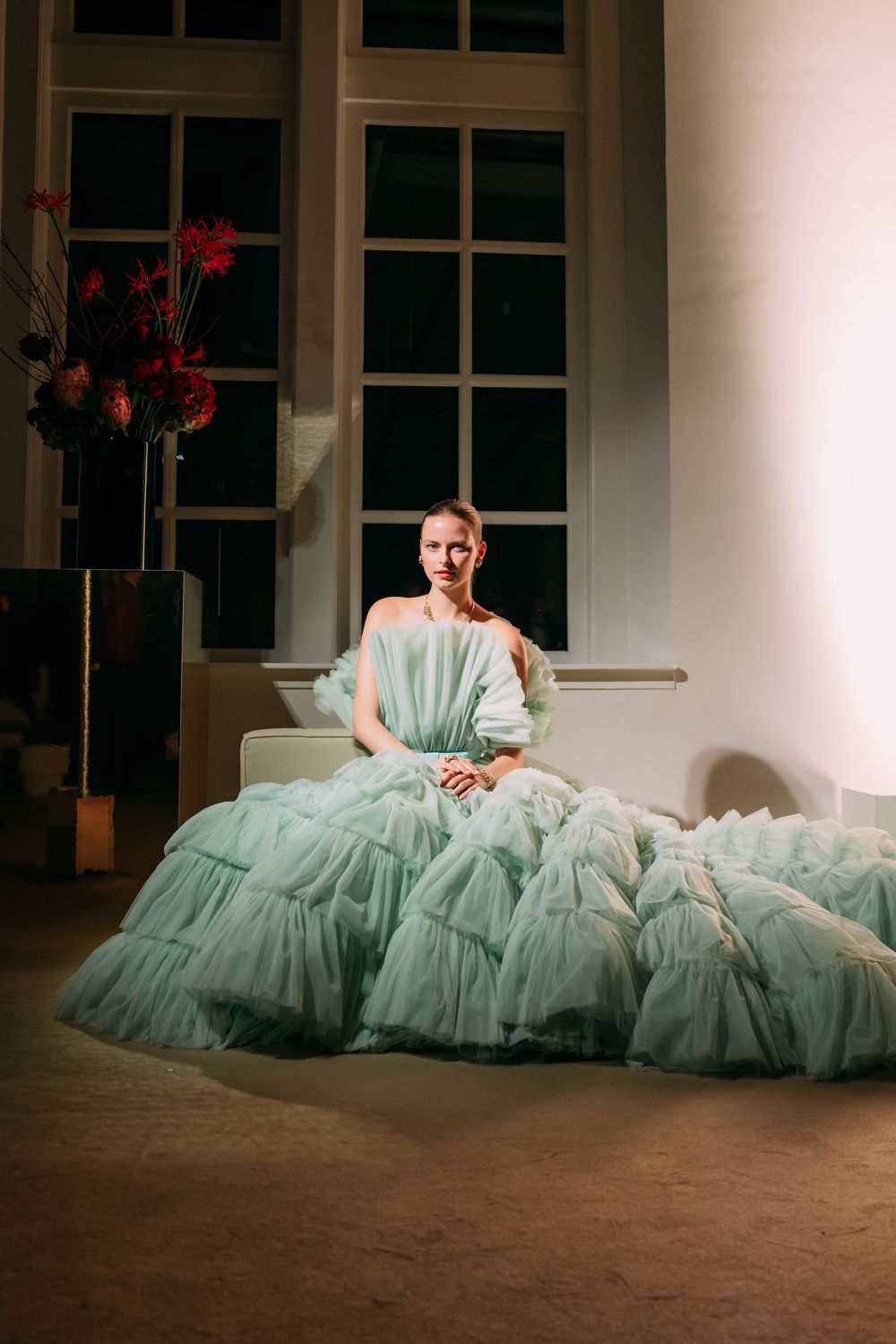 A series of photos showing a flowing mint green tulle gown against a rustic wooden floor in an elegant interior setting.