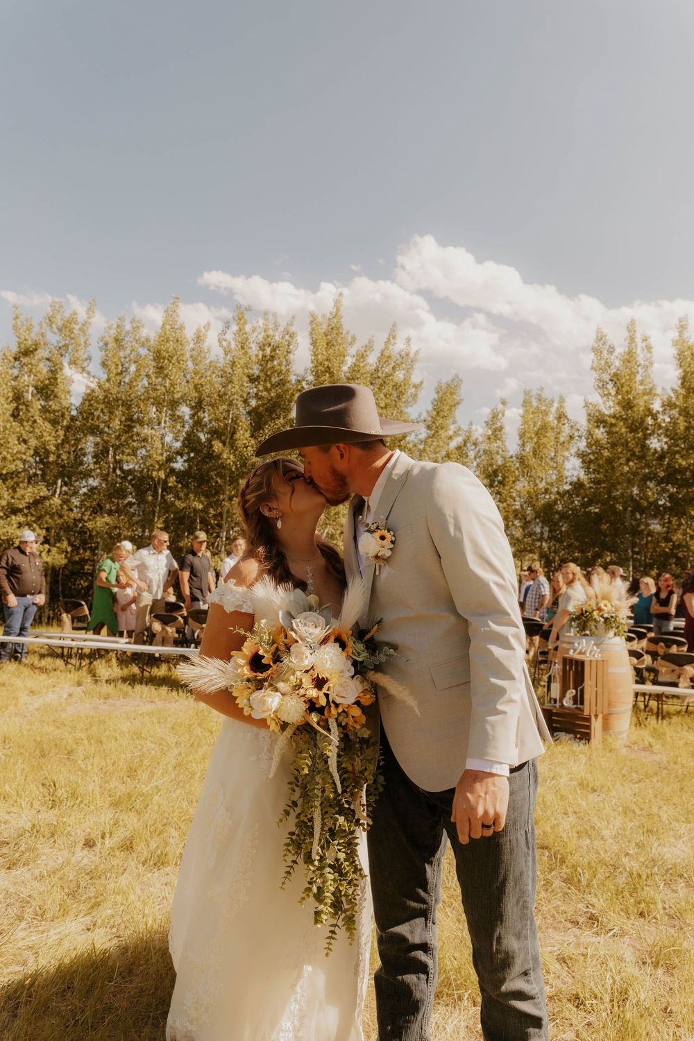 Outdoor country wedding ceremony in a field with rustic decorative elements.