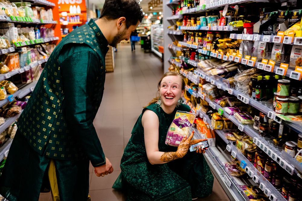 Two people in green attire browsing snacks in a supermarket aisle.